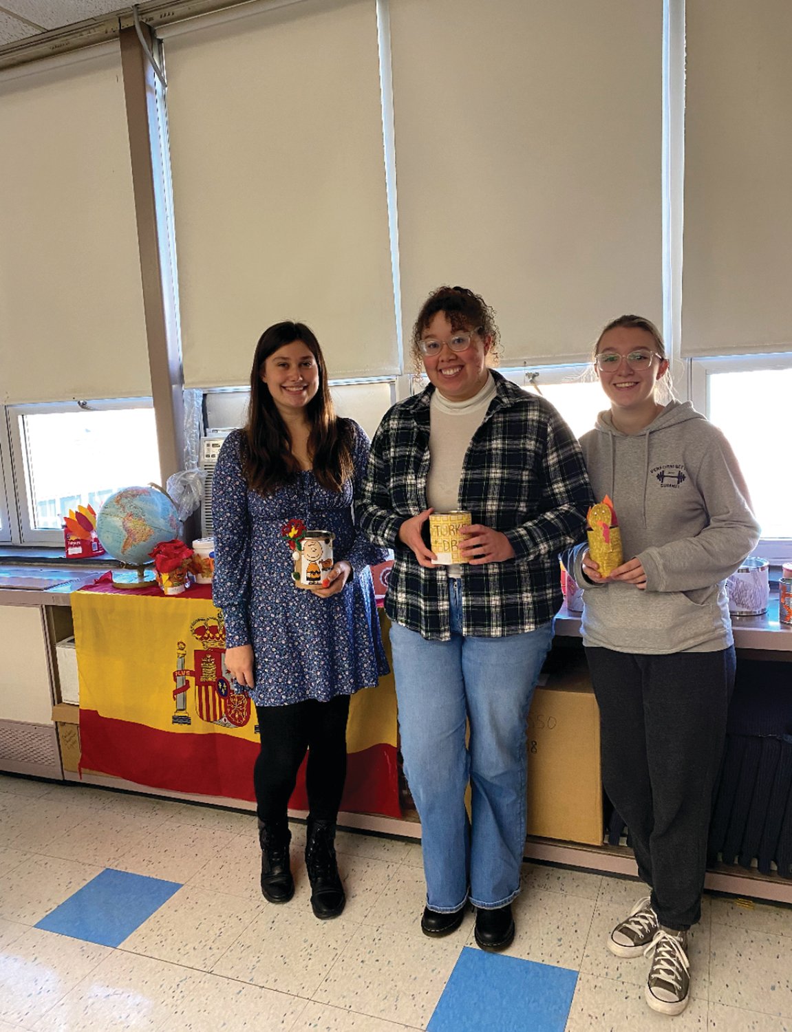 From left to right, NHS President Glorianna Crichlow, NHS Vice President Emily Patenaude, and NHS Historian Mackenzie Hanna, members of JHS National Honor Society, pose with their cans.